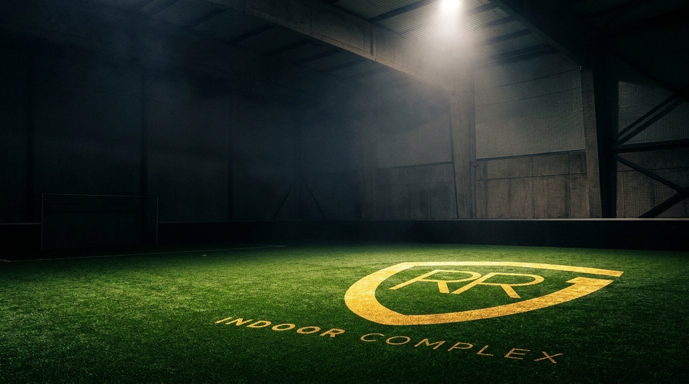 The gold RR Indoor Complex crest painted on the indoor turf under a spotlight